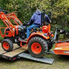 HD Ramps EZ Traction hook-end stub-foot ramps loading a tractor, supplier catalog photograph